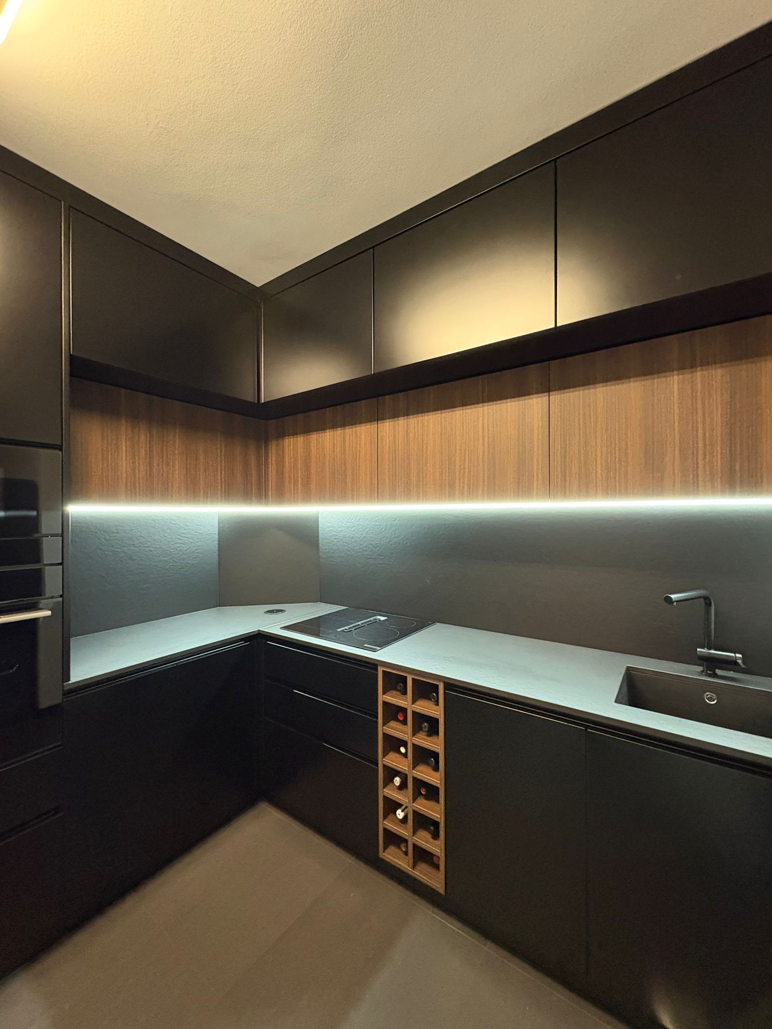 Cozinha remodelada pela Valora, com bancada em L e iluminação por baixo dos armários