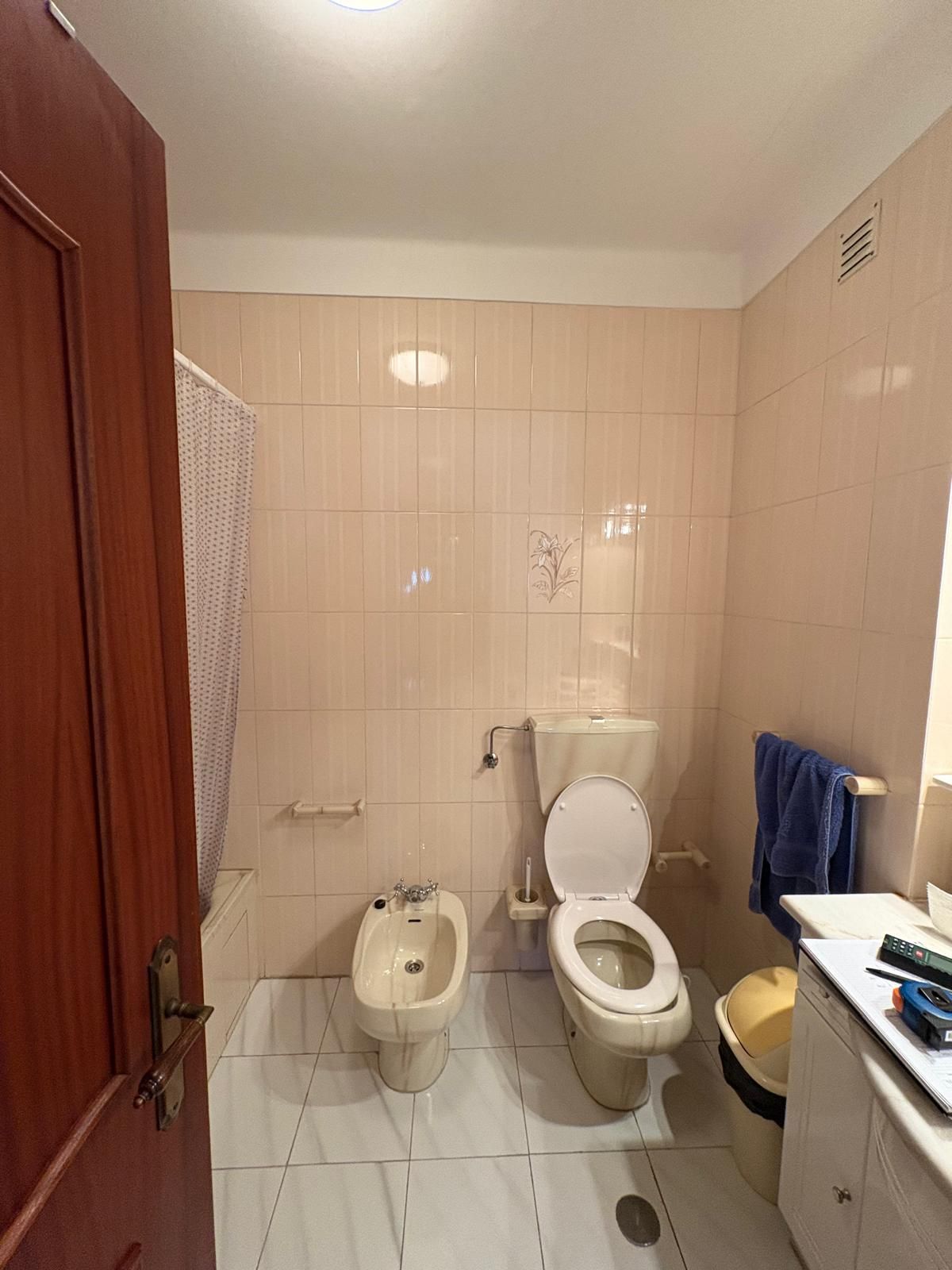 Casa de banho antes da remodelação, com azulejo e louças cor-de-rosa